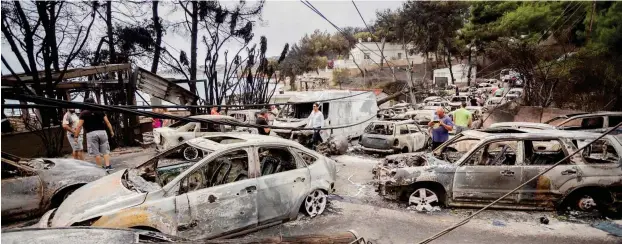  ?? Foto: dpa/Christoph Soeder ?? Verbrannte Autos stehen in Mati auf der Straße, nachdem dort ein Feuer gewütet hat.