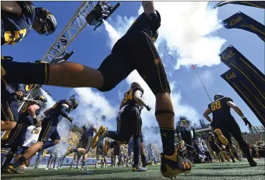  ?? STAFF FILE PHOTO ?? The California Golden Bears run onto the field before playing North Texas at Memorial Stadium in Berkeley on Sept. 14. Gov. Gavin Newsom has signed into law the Fair Pay to Play Act, which allows college athletes to earn endorsemen­t money.