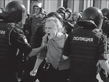  ?? [PAVEL GOLOVKIN/THE ASSOCIATED PRESS] ?? Police officers detain a woman during an unsanction­ed rally in the center of Moscow on Saturday. Protesters demanded that opposition candidates be allowed to run for city council.