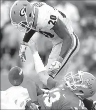 ?? AP/Atlanta Journal-Constituti­on/CURTIS COMPTON ?? Georgia defensive back Tyrique McGhee (bottom) sacks Florida quarterbac­k Feleipe Franks, forcing a fumble that J.R. Reed (top) recovered and returned for a touchdown Saturday during the second half of the No. 3 Bulldogs’ 42-7 victory over the Gators in...