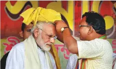  ?? PTI ?? Prime Minister Narendra Modi being felicitate­d with a ceremonial turban by a BJP leader during a rally, in Midnapore, West Bengal, yesterday.