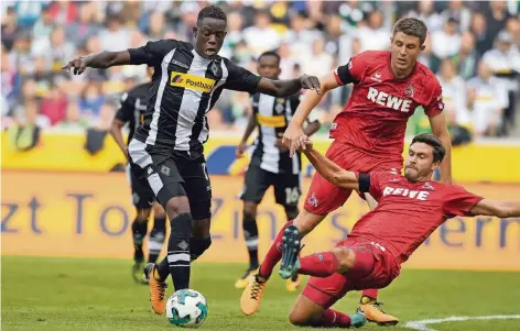  ?? FOTO: DPA ?? Fix unterwegs: Der Gladbacher Denis Zakaria (li.) dribbelt, die Kölner Jonas Hector (re.) und Dominique Heintz versuchen, ihn zu stoppen.