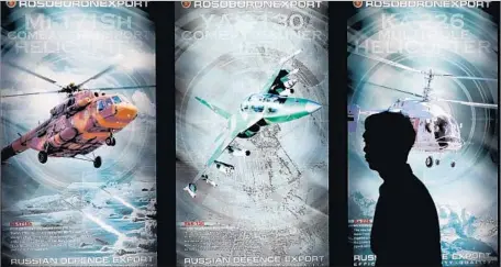  ?? Mike Clarke AFP/Getty Images ?? RUSSIAN MILITARY aircraft ads at a trade show. Moscow says the sanctions aim to give the U.S. dominance in the global arms market.