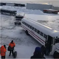 ?? THE CANADIAN PRESS ?? Passengers board buses Sunday after being stuck on the tarmac in frigid temperatur­es for several hours at Goose Bay Airport.