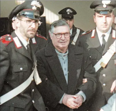  ?? AP PHOTO ?? In this Jan. 16, 1996 file photo, Mafia ‘’boss of bosses’’ Salvatore ‘’Toto’’ Riina, center, enters handcuffed into Bologna’s bunker-courtroom, escorted by Carabinier­i, Italian paramiliar­y police, in Bologna, Italy.