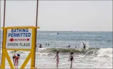  ?? Johnny Milano / New York Times ?? A lifeguard on a Jet Ski at monitors for sharks. Amid an increase in shark sightings, lifeguards are increasing patrols.