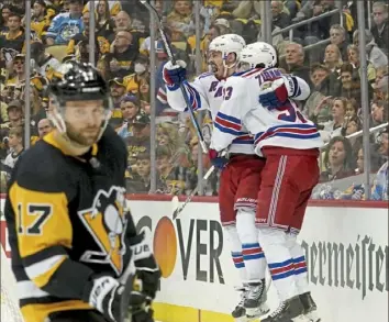  ?? ?? Rangers center Mika Zibanejad congratula­tes left winger Chris Kreider after he scored on Penguins goaltender Louis Domingue in the second period. Bryan Rust is at left.