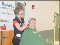  ?? STAFF PHOTOS BY JAMIE ANFENSON-COMEAU ?? Dawn Camp of Port Tobacco has her head shaved by Sam Baker of Sports Clips in La Plata during the “Going Bald for a Cause Southern Maryland” fundraiser for childhood cancer research Saturday.