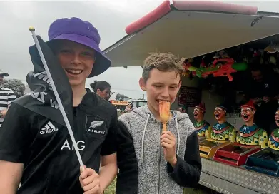  ?? PAUL MITCHELL/STUFF ?? Campbell Baim, 12, left, Hayden Rodgers, 11, and their families come to the Foxton Beach fair from opposite sides of the North Island every New Year.