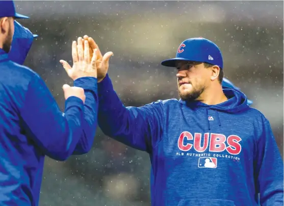  ??  ?? GETTY IMAGES Kyle Schwarber gives and receives congratula­tions after the Cubs’ victory Tuesday against the Indians at Progressiv­e Field. His two home runs led the way.
