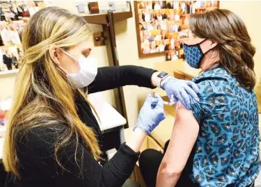  ??  ?? Senate staffer Kendra Hawkins is inoculated with the Moderna vaccine by Mississipp­i Department of Health Pharmacist Anna Ward at the State Capitol. (Photo by Vickie D. King, Mississipp­i Today)