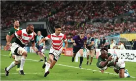  ??  ?? Makazole Mapimpi dives for the line to score the opening try for South Africa. Photograph: Cameron Spencer/Getty Images