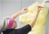  ??  ?? Along with Hollett, artist Tonya Corkey is busy working away creating a massive dragon, weighing more than 135 kilograms.