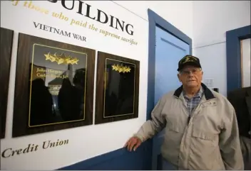  ?? JULIA MALAKIE, LOWELL SUN FILE ?? Norman Albert, now former chairman of the Board of Trustees of the War Memorial stands by newly installed plaques honoring Shirley’s dead, at the town’s War Memorial Building in November 2017. IC Federal Credit Union funded the plaques, which include an empty plaque in the unfortunat­e event of future casualties.