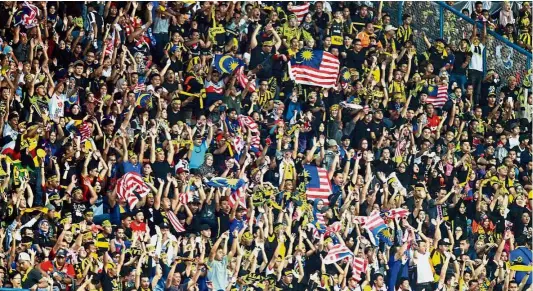  ??  ?? Lively crowd: Malaysian supporters at the SEA Games football semi-final against Indonesia at the Shah Alam Stadium.