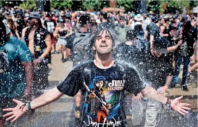  ?? ?? A festival goer cools down with fresh water while taking part in the Hellfest metal music festival in Western France. (AFP)