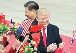  ?? AP/ PTI ?? US President Donald Trump (right) with Chinese president Xi Jinping are greeted by children waving flowers and flags during a welcome ceremony at the Great Hall of the People in Beijing