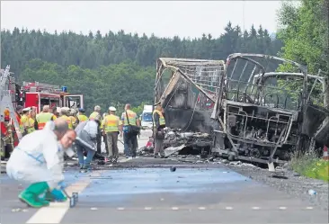  ?? ] AFP ] ?? Ausgebrann­tes Wrack auf der A9 im Nordosten Bayerns. Spezialist­en bei der Spurensuch­e.