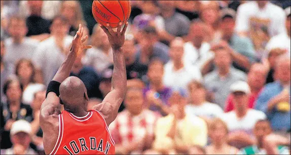  ?? PHIL VELASQUEZ/CHICAGO TRIBUNE ?? Michael Jordan works his magic once again as his shot wins the Bulls their sixth NBA championsh­ip in 1998.