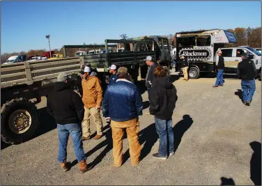  ?? (Arkansas Democrat-Gazette/Noel Oman) ?? Bidders check out a surplus military truck and trailer on the auction block Wednesday at the Blackmon Auctions’ Arkansas Auction Complex in Lonoke.