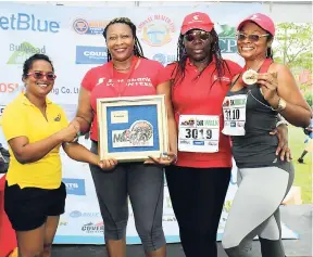  ?? PHOTOS BY ASHLEY ANGUIN ?? From left: University of the West Indies, Western Jamaica Campus’ Inderia Adjudah, presenting a plaque to second-place Corporate Challenge winners – Scotiabank’s Marviet Webb, Janet Richards and Andrea Rhule-Hudson.