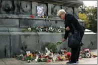  ?? AP/FILIP DVORSKI ?? A woman leaves flowers Wednesday near the photo of Viktoria Marinova on the Liberty Monument in Ruse, Bulgaria. The television journalist was raped and strangled Saturday.