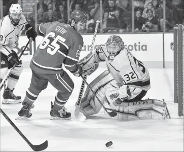  ?? Minas Panagiotak­is Getty Images ?? ANDREW SHAW of the Montreal Canadiens and Kings goaltender Jonathan Quick hold a meeting at the net as the puck trickles away during the Kings’ victory on Thursday at the Bell Centre in Montreal.