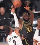  ?? KIM KLEMENT/USA TODAY SPORTS ?? Lakers forward Lebron James passes between Trail Blazers guard Gary Trent Jr., left, and center Hassan Whiteside on Monday.