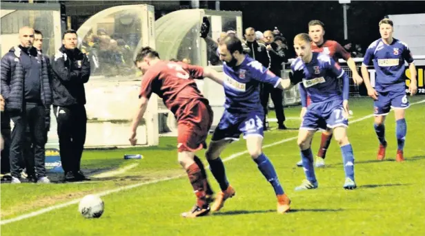  ??  ?? Bangor City (blue) and Holyhead Hotspur battle for possession during Friday night’s Welsh Cup tie at Nantporth