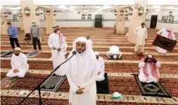  ?? AMR NABIL THE ASSOCIATED PRESS ?? Saudi cleric Hammoud Al-Labban recites the call to prayers as worshipper­s wearing face masks pray at al-Mirabi Mosque in Jiddah, Saudi Arabia, on Sunday.