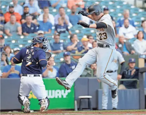  ?? ASSOCIATED PRESS ?? The Pirates’ David Freese scores easily ahead of the throw to Brewers catcher Manny Pina for one of Pittsburgh’s six runs in the first inning on Tuesday.