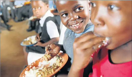  ?? Picture: FILE ?? TIME TO SNACK: Children enjoying lunch as a result of a feeding scheme. New research is suggesting that stunting is not necessaril­y set in early children, and there are opportunit­ies for children to ‘catch up’ in middle childhood