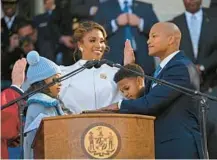  ?? ?? Gov. Wes Moore takes the oath of office Wednesday in Annapolis as his wife, Dawn, and children, Mia and James, look on.