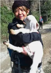  ??  ?? Lim trying her hand at goat herding. ‘I love animals, and they love me too,’ she says.