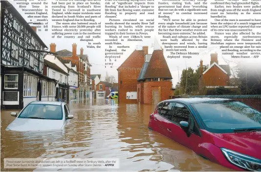  ??  ?? Flood water surrounds abandoned cars left in a flooded street in Tenbury Wells, after the River Teme burst its banks in western England on Sunday after Storm Dennis. – AFPPIX