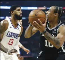  ?? Associated Press ?? ONE-ON-ONE — The San Antonio Spurs’ DeMar DeRozan (10) is defended by the Los Angeles Clippers’ Paul George (13), a Knight High grad, during the first half on Monday in Los Angeles. DeRozan was called for a flagrant-1 foul during the game after elbowing George in the nose. The Clippers won 108-105.