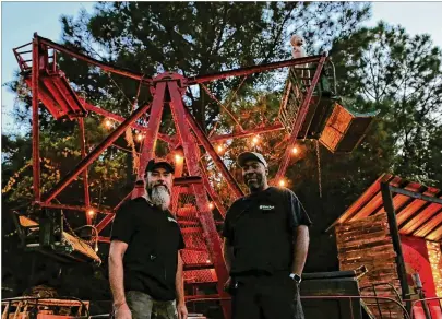  ?? SAVANNAH MORNING NEWS PHOTOS ?? Co-owners of Wicked South Production, Tom Mccormick (left) and Emeka Nwokeji, pose in front of a Ferris Wheel formerly seen on “Fear The Walking Dead.”