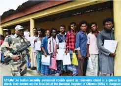  ?? -— AFP ?? ASSAM: An Indian security personnel stands guard as residents stand in a queue to check their names on the final list of the National Register of Citizens (NRC) in Burgoan village in Morigoan district yesterday.