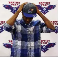  ?? Arkansas Democrat-Gazette/MITCHELL PE MASILUN ?? Baptist Prep senior guard Issac McBride tries on a University of Kansas hat after signing his letter of intent to play for the Jayhawks on Wednesday.