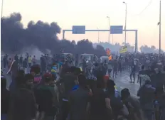  ?? (Thaier Al-Sudani/Reuters) ?? DEMONSTRAT­ORS GATHER at a protest after the lifting of the curfew in Baghdad on Saturday, following four days of nationwide anti-government protests that turned violent.