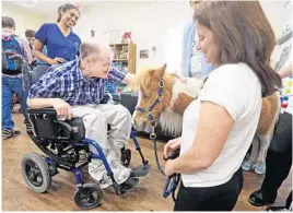  ?? RED HUBER/STAFF PHOTOGRAPH­ER ?? Kenny, a longtime resident at the Russell Home for Atypical Children, gets in some therapy time with Shelton the during the horse’s hour-long visit to the facility Thursday.