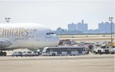  ??  ?? Vehículos de emergencia rodean el avión de Emirates Airlines puesto ayer en cuarentena en Nueva York, luego de que varios pasajeros se reportaron enfermos.