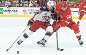  ?? DUANE BURLESON/AP ?? Columbus Blue Jackets center Boone Jenner (38) tries to hold off Detroit Red Wings defenseman Danny Dekeyser (65) during the third period on Tuesday in Detroit.