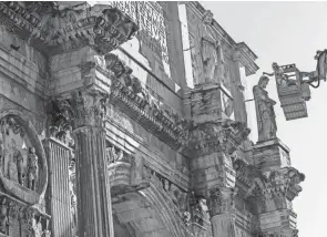  ?? DOMENICO STINELLIS/AP ?? Restorers work Thursday on one of the eight statues of Dacian warriors adorning the triumphal Arch of Constantin­e in front of the Colosseum in Rome.