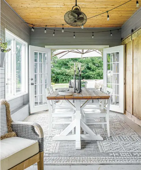  ??  ?? Erica painted the walls of the sunroom, which used to be the same cedar planks as the ceiling. Seating and a dining set make it an inviting indoor-outdoor space, and the outdoor dining table is another one of Erica and her husband’s furniture creations.