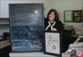  ?? KRISTI GARABRANDT — THE NEWS-HERALD ?? Amy Lauria, a Painesvill­e resident and artist, shows the two art pieces she donated to Forbes House in hopes of inspiring the clients that call the shelter home.