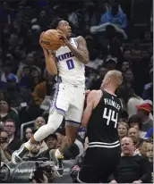  ?? MARK J. TERRILL — THE ASSOCIATED PRESS ?? Sacramento's Malik Monk, left, shoots as the Clippers' Mason Plumlee defends during Friday night's game in Los Angeles. Monk scored 45 points in the Kings' win.