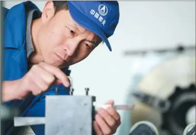  ?? PROVIDED TO CHINA DAILY ?? Xu Liping checks a tool used to process highly explosive solid propellant designed for use in rocket engines at the Xi’an Aerospace Chemical Propulsion Factory in Shaanxi province.