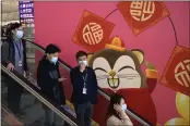  ?? NG HAN GUAN — THE ASSOCIATED PRESS ?? People wear face masks as they ride an escalator at the Hong Kong Internatio­nal Airport in Hong Kong on Tuesday.