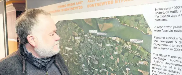  ??  ?? Emrys Llywelyn looking at plans of the Caernarfon-Bontnewydd bypass near his home